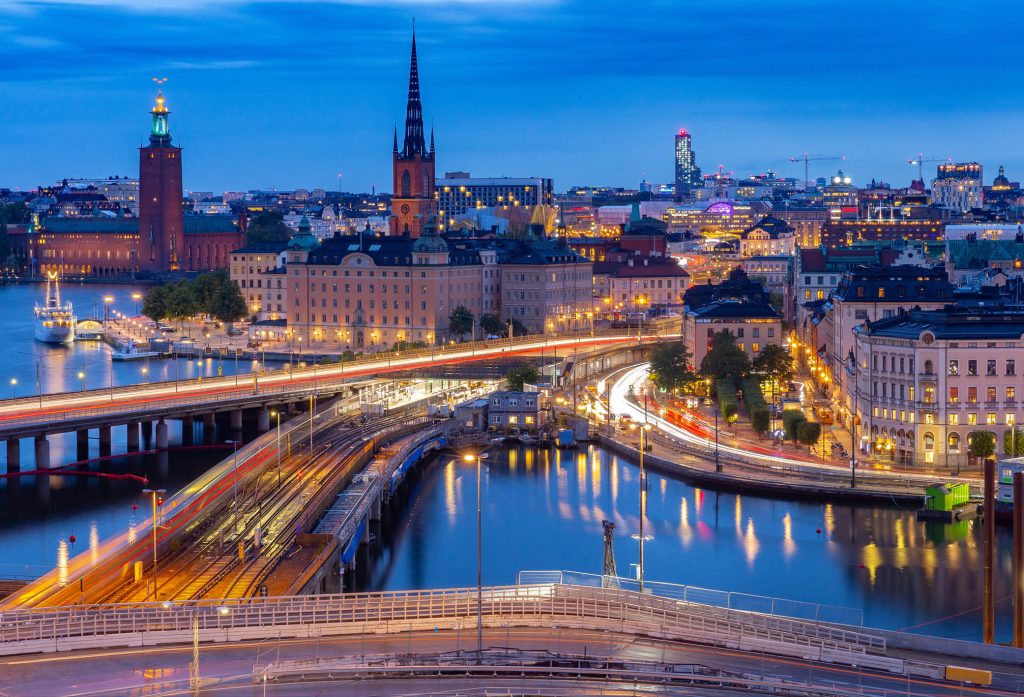 Bild över Stockholm, vatten, stadshuset, bostäder och upplysta vägar nattid. Symbolisk bild för Sociala Missionens seminariedag med fokus på diskussioner kring boende ekonomi och hälsa för äldre i en föränderlig värld.