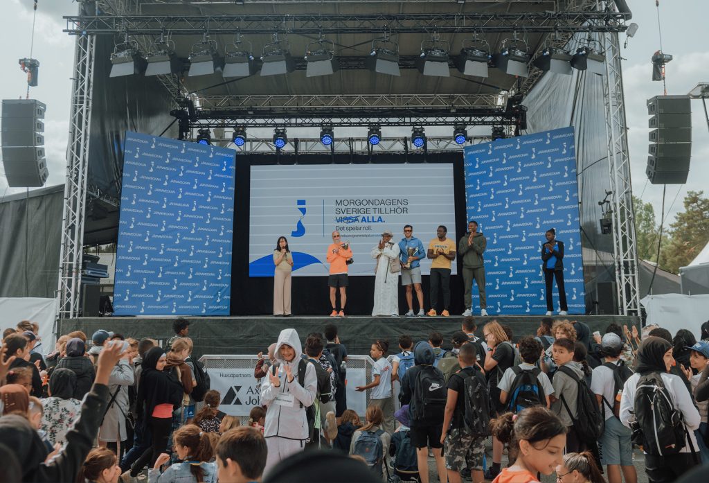 Bild från en stor scen under Järvaveckan 2023, med många människor från olika bakgrunder framför scenen.